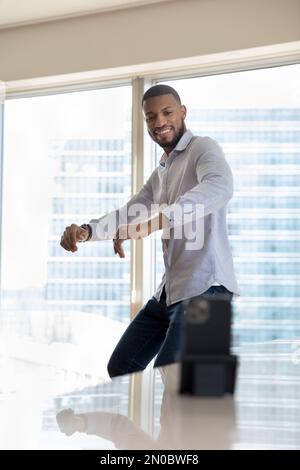 Glücklicher gutaussehender energetischer Influencer, Blogger-Mann, der vor der Kamera tanzt Stockfoto