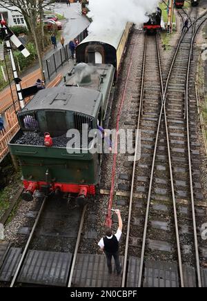 Der Feuerwehrmann des GWR-Panzers Nr. 6430 holt gleich den Einlinientempel vom Wegweiser in Buckfastleigh auf der South Devon Railway ab. Stockfoto