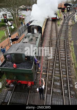 Der Feuerwehrmann des GWR-Panzers Nr. 6430 holt den Einlinientempel vom Wegweiser am Buckfastleigh-Bahnhof an der South Devon Railway ab. Stockfoto