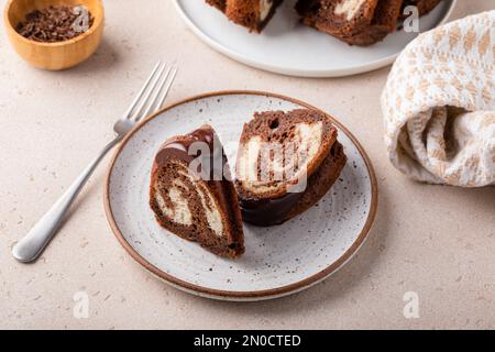 Schokoladenkuchen aus Marmor oder Zebrakuchen mit Schokoladenglasur, zwei Scheiben auf einem Teller Stockfoto