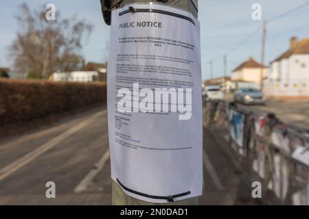 Rochford, Großbritannien. Februar 2023. Öffentliche Bekanntmachung des Rochford District Council zur Verkehrsregelung. An Masten angebrachte Schilder mit Vorstadtkulisse, einschließlich Fahrzeugen, Fußgängerschutzbarrieren und Wohnhäusern. Demonstranten von Save Holt Farm Oak Tree protestieren, um eine 100 Jahre alte Eiche zu retten. Der Baum wird voraussichtlich bis April 2023 gefällt. Penelope Barritt/Alamy Live News Stockfoto