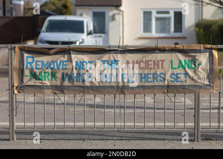 Rochford, Großbritannien. Februar 2023. Handgemaltes Banner mit den Sprüchen 22:28, „Entfernen Sie nicht das alte Wahrzeichen…“, das an einem Straßenzaun in Rochford angebracht ist. Betont Erbe und Tradition in einer Wohngegend. Demonstranten von Save Holt Farm Oak Tree protestieren, um eine 100 Jahre alte Eiche zu retten. Der Baum wird voraussichtlich bis April 2023 gefällt. Penelope Barritt/Alamy Live News Stockfoto