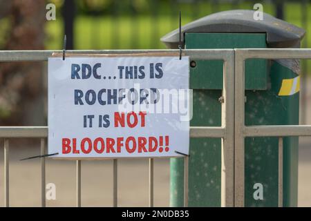 Rochford, Großbritannien. Februar 2023. Auf einem gedruckten Schild, das an einem Metallzaun in Rochford, Essex, angebracht ist, steht: „THIS IS ROCHFORD – IT IS NOT BLOORFORD!!“ In fettgedrucktem Rot- und Schwarzweißtext. Die Botschaft betont bürgerliche Identität und lehnt wahrgenommene Falschbenennungen oder Entwicklungsbranding ab. Demonstranten von Save Holt Farm Oak Tree protestieren, um eine 100 Jahre alte Eiche zu retten. Der Baum wird voraussichtlich bis April 2023 gefällt. Penelope Barritt/Alamy Live News Stockfoto
