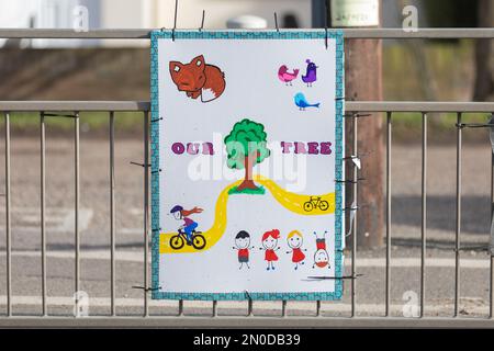 Rochford, Großbritannien. Februar 2023. Kindgerechte Kunstwerke, die auf einem Zaun in Rochford montiert sind, mit Bäumen, Pfaden, Tieren und Fahrrädern. Feiert Natur, Spiel und Zusammensein. Demonstranten von Save Holt Farm Oak Tree protestieren, um eine 100 Jahre alte Eiche zu retten. Der Baum wird voraussichtlich bis April 2023 gefällt. Penelope Barritt/Alamy Live News Stockfoto