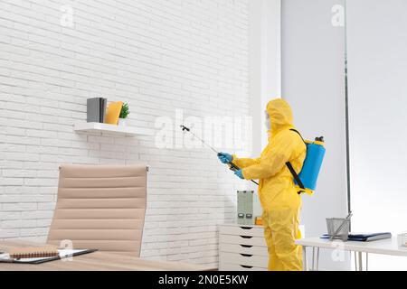 Hausmeister in Schutzanzug Desinfektionsbüro zur Verhinderung der Ausbreitung von COVID-19 Stockfoto