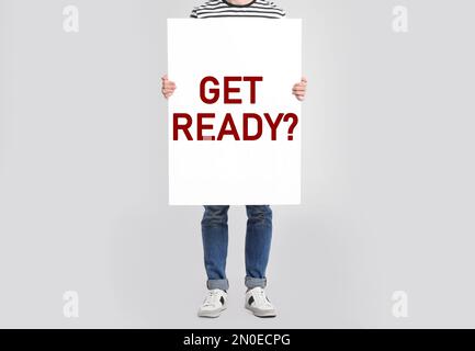 Mann mit Poster und Text „bereit machen“? Auf hellgrauem Hintergrund, Nahaufnahme Stockfoto