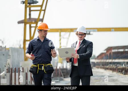Männliche Ingenieure prüfen und kontrollieren die Arbeit der Mitarbeiter und die Qualität der hergestellten Produkte, um die Standards zu erfüllen. In der Industrie Stockfoto