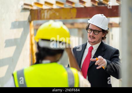 Männliche Ingenieure prüfen und kontrollieren die Arbeit der Mitarbeiter und die Qualität der hergestellten Produkte, um die Standards zu erfüllen. In der Industrie Stockfoto