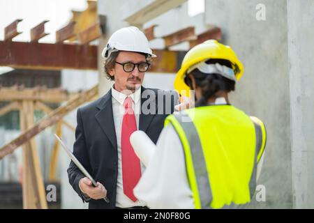 Männliche Ingenieure prüfen und kontrollieren die Arbeit der Mitarbeiter und die Qualität der hergestellten Produkte, um die Standards zu erfüllen. In der Industrie Stockfoto