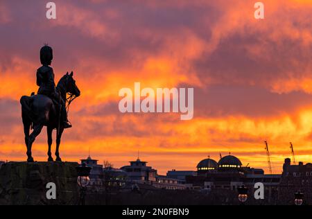 Edinburgh, Schottland, Vereinigtes Königreich, 5. Februar 2023. Großbritannien Wetter dramatischer farbenfroher Sonnenuntergang Himmel. Der Sonnenuntergang verwandelte den Himmel in leuchtende orangefarbene Farben, die über den Princes Street Gardens mit dem Royal Scots Greys Monument blickten. Kredit: Sally Anderson/Alamy Live News Stockfoto