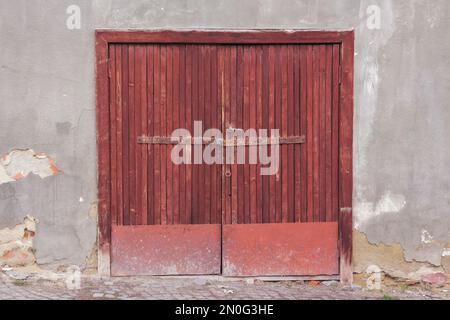 Garagentür an einer alten Fassade. Architekturelement Stockfoto