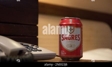 Portugal, Vilamoura, 02.01.2023. Auf dem Tisch neben dem Festnetz steht eine eiserne Dose sagres-Bier, portugiesisches Bier. Stockfoto