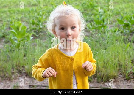 Das Ist Toll. Überraschendes Mädchen. Das Porträt für Kleinkinder sieht überrascht aus, in völligem Unglauben, mit weit aufsteigenden Augenbrauen und offenem Mund. Überrascht und schockiert Stockfoto