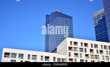 Blaue Vorhangwand aus getöntem Glas und Stahlkonstruktionen unter blauem Himmel. Ein Bruchteil eines Gebäudes. Glasfassaden an einem hellen, sonnigen Tag Stockfoto