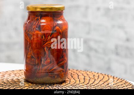 Rote eingelegte Flusskrebse in einem Glasbehälter, Nahaufnahme mit selektivem Weichzeichner Stockfoto