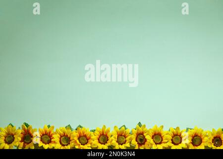 Sonnenblumen-Kunstblumen-Hintergrundbild im blauen Raum Stockfoto