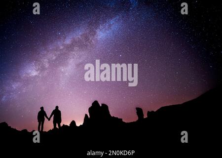 Liebevolles Paar vor der Milchstraße, das die Sterne anschaut. Metapher für Astrologie Zodiac-Liebeskompatibilität Stockfoto