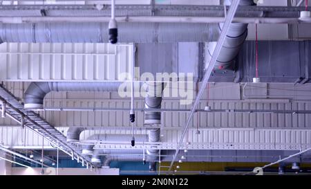 Beleuchtung und Lüftungsanlage an der Decke der Supermarkthalle. Deckenkonstruktion. Stockfoto