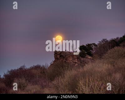 Menschen, die beobachten, wie der Full Snow Moon über den Gipfel der Black Rocks Derbyshire UK HDR steigt Stockfoto