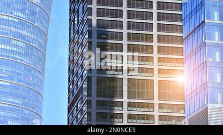 Fassadentextur eines verspiegelten Bürogebäudes aus Glas. Fragment der Fassade. Blick von unten auf moderne Wolkenkratzer im Geschäftsviertel Stockfoto