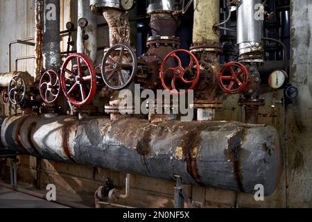 Kesselraum für die Dampferzeugung in der industriellen Produktion der Fabrik. Altes Rohrsystem aus dem Kesselraum Stockfoto