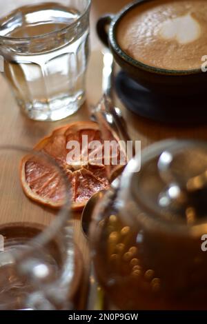 Marokkanischer Tee und Kaffee auf einem Holzteller in einem Café mit Weinscheiben und Büchern. Gemütlich. Innenraum. Stockfoto