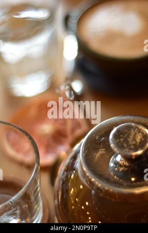 Marokkanischer Tee und Kaffee auf einem Holzteller in einem Café mit Weinscheiben und Büchern. Gemütlich. Innenraum. Stockfoto