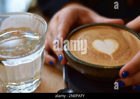 Marokkanischer Tee und Kaffee auf einem Holzteller in einem Café mit Weinscheiben und Büchern. Gemütlich. Innenraum. Stockfoto