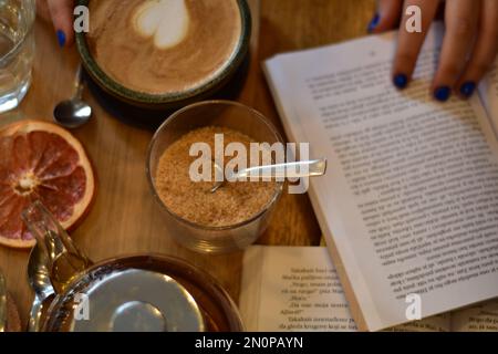 Marokkanischer Tee und Kaffee auf einem Holzteller in einem Café mit Weinscheiben und Büchern. Gemütlich. Innenraum. Stockfoto