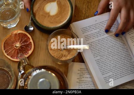 Marokkanischer Tee und Kaffee auf einem Holzteller in einem Café mit Weinscheiben und Büchern. Gemütlich. Innenraum. Stockfoto