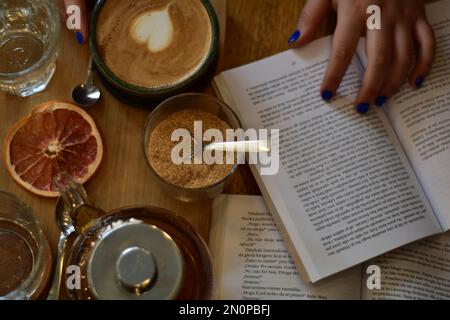 Marokkanischer Tee und Kaffee auf einem Holzteller in einem Café mit Weinscheiben und Büchern. Gemütlich. Innenraum. Stockfoto