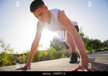 Ein Läufer in Startposition während eines Workouts, Wellness- und Outdoor-Sportkonzepts Stockfoto