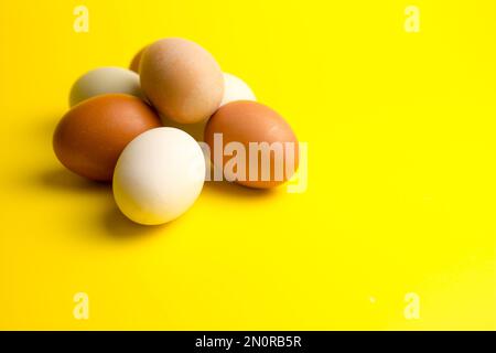 Andere Farbe Hühnereier aus Freilandhaltung auf gelbem Hintergrund Stockfoto