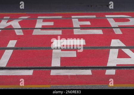 Halten Sie ein gut lesbares Informationsschild mit rotem Hintergrund und weißer Beschriftung an einer Straßenbahnlinie in Melbourne, Australien. Stockfoto