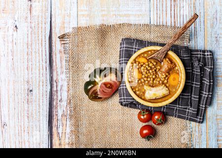 Stillleben mit Rezept für typischen escañol-Linseneintopf mit Chorizo, Gemüse und Tomaten Stockfoto