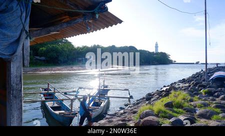 Garut, Indonesien - Dezember 12,2022 : Ein Fischer, der am Ufer neben seinem Boot steht Stockfoto