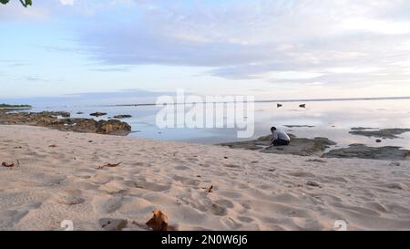 Männer am Strand und Sonnenuntergänge am Strand. Paradiesstrand. Tropisches Paradies, weißer Sand, Strände und klares Wasser. Eine Landschaft mit Sonnenuntergängen am Meer Stockfoto