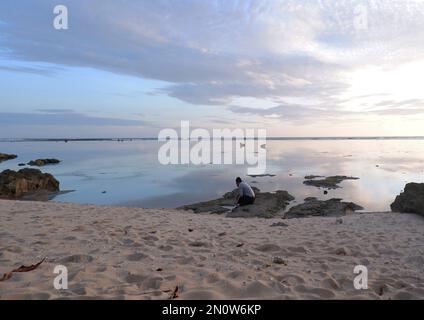 Männer am Strand und Sonnenuntergänge am Strand. Paradiesstrand. Tropisches Paradies, weißer Sand, Strände und klares Wasser. Eine Landschaft mit Sonnenuntergängen am Meer Stockfoto