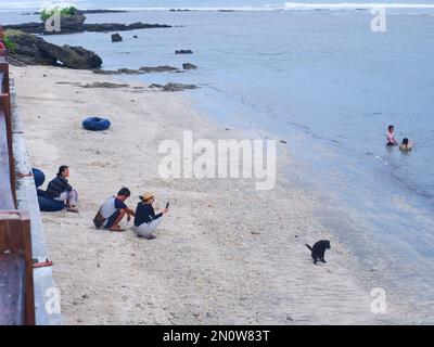 Garut, Indonesien - Dezember 12,2022 : Menschen, die an einem wunderschönen tropischen Strand mit blauem Himmel und abstrakter Textur im Hintergrund spielen und schwimmen o Stockfoto