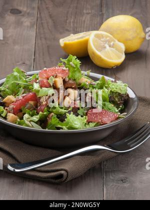 Grüner Salat mit Baby-Rucola, Zitrusfrüchten, getrockneten Feigen, Croutons, Sesam und Sonnenblumenkernen. Gesunde und leichte Rezepte.Vegan. Vegetarisch Stockfoto