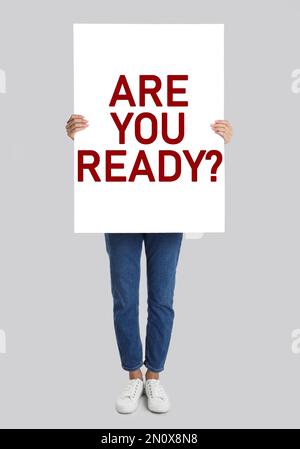 Frau mit Poster und Text: Bist du bereit? Auf hellgrauem Hintergrund Stockfoto