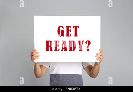 Mann mit Poster und Text „bereit machen“? Auf hellgrauem Hintergrund Stockfoto