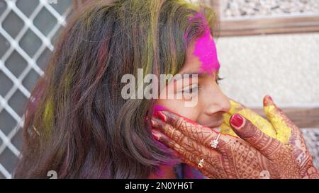 Glückliche Mutter, die sich mit ihrer Tochter zu Hause beim holi Festival amüsiert Stockfoto