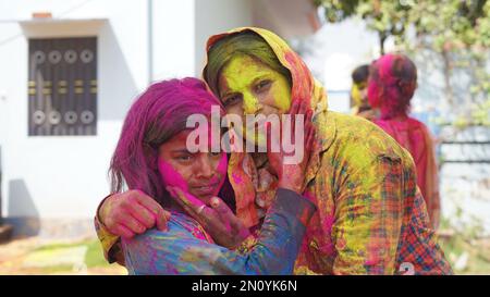 Glückliche Mutter, die sich mit ihrer Tochter zu Hause beim holi Festival amüsiert Stockfoto