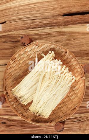 Frischer Golden Needle Pilz oder Enoki, Enokitake Flammulina Velutipes auf Holztisch, Draufsicht Stockfoto