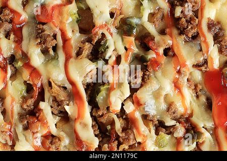 Macro-Shoot-Struktur von Beef Pizza mit Paprika, Chilisauce, Zwiebeln und Käse Stockfoto