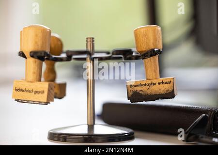 25. Januar 2023, Hessen, Frankfurt/Main: Stempel mit der Aufschrift "Baumkataster aufgezeichnet" und "professionell inspiziert" hängen in einem Halter im Grünflächenbüro. Die Grünlandbüros der Gemeinden führen regelmäßig Baumbesichtigungen in öffentlichen Grünflächen durch. Ein Bruch des grünen Astes, das plötzliche Abreißen einzelner, vollständig belaubter Äste, kann nicht einmal im Rahmen einer regelmäßigen Bauminspektion vorhergesehen werden. In Frankfurt ist das Grünflächenbüro für fast 190.000 Bäume entlang der Straßen, in Parks und auf Spielplätzen verantwortlich. Der Klimawandel nimmt erheblich zu Stockfoto