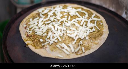 Wir toasten Käse-Quesadillas auf einem heißen Grill. Käse und würzige Paste als Belag für die Tortilla. Stockfoto