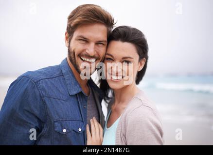 Sie sind füreinander geschaffen. Ein junges Paar, das am Strand zusammenstand. Stockfoto
