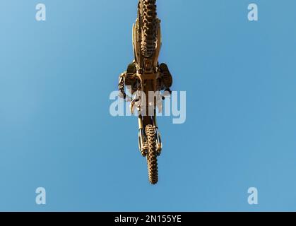 Was hoch geht, muss runter. Die Unterseite eines Motocross-Fahrers in der Luft während eines Rennens. Stockfoto